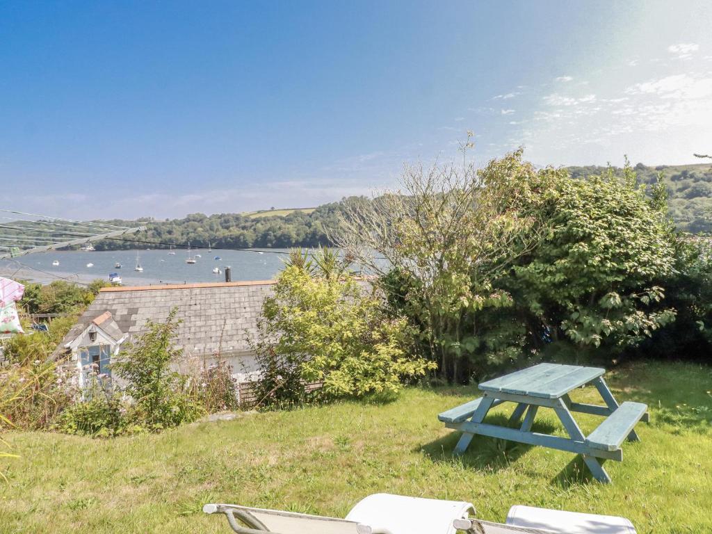 a blue picnic table in the grass next to a lake at Kiln Cottage in Fowey