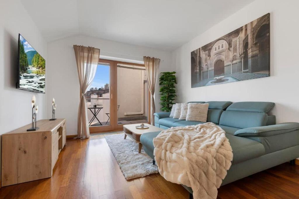 a living room with a blue couch and a table at Urban Elegance Retreat in Bratislava