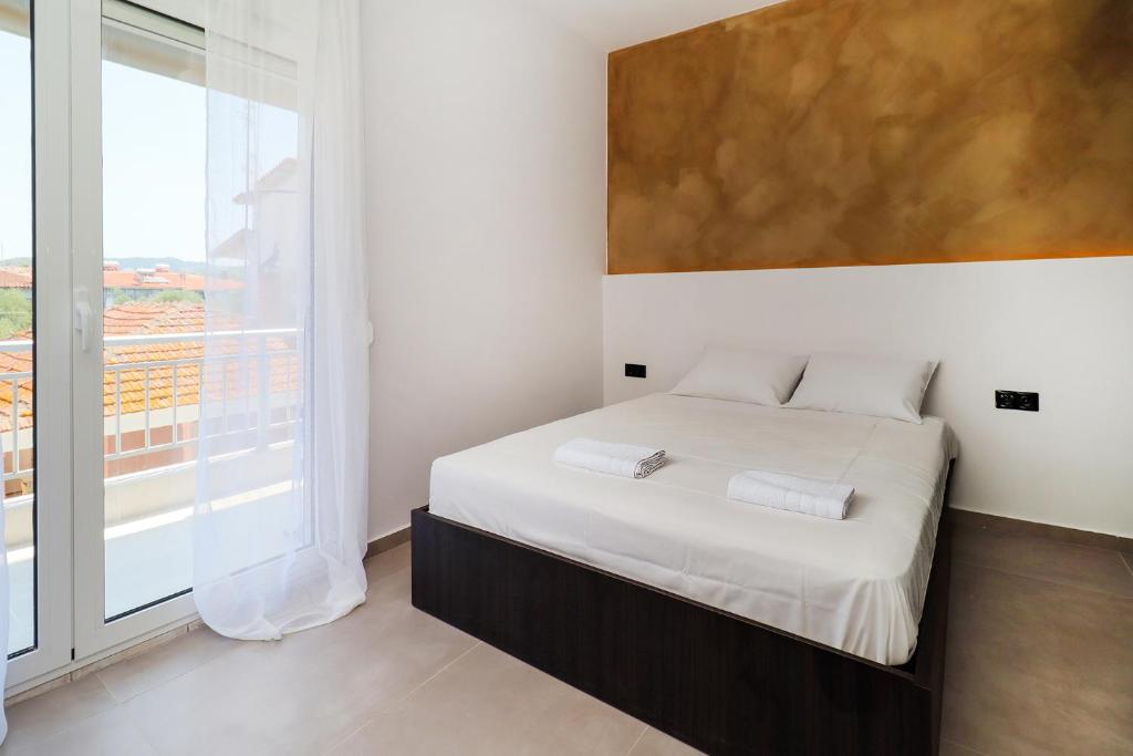 a bedroom with a bed and a large window at KELIFOS Blue in Pefkochori