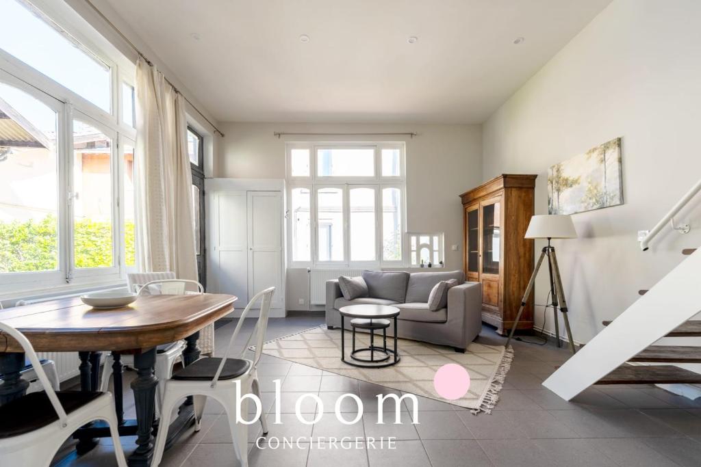 a living room with a table and a couch at Loft indépendant avec parking privé in Nancy