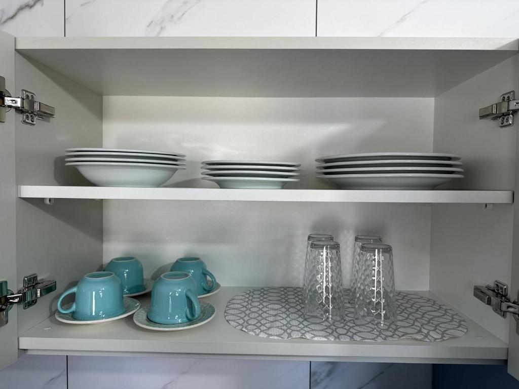 a kitchen cabinet with plates and bowls and dishes at Casa Azul, Privativa, Confortável, AR, Wi-Fi in Joinville
