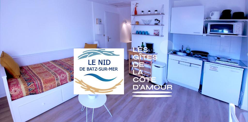 una stanza con un letto e un cartello in cucina di LE NID DE BATZ SUR MER-Studio-Les Gîtes de la Côte d'Amour a Batz-sur-Mer