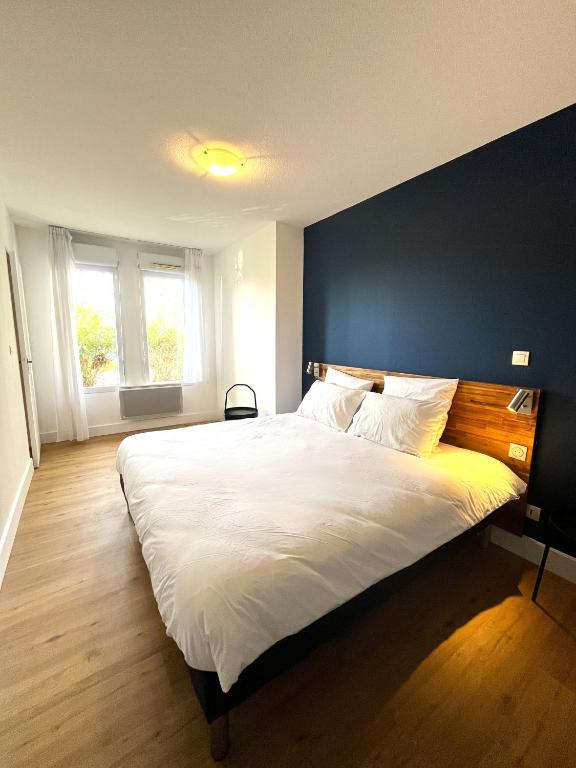 a bedroom with a large bed with a blue wall at Les appartements du Clos de la Chartreuse By Ateya in Aix-en-Provence