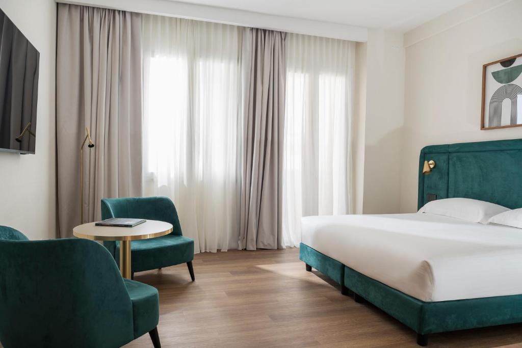 a hotel room with a bed and a table and chairs at Parioli Hotel Rimini in Rimini