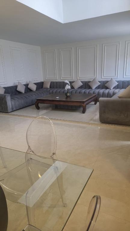 a living room with a couch and a glass table at villa pools bbq lounge in Oujda