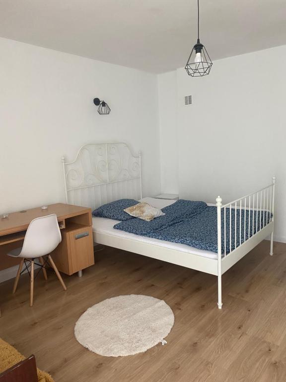 a bedroom with a bed and a desk and a chair at Monika House in Warsaw