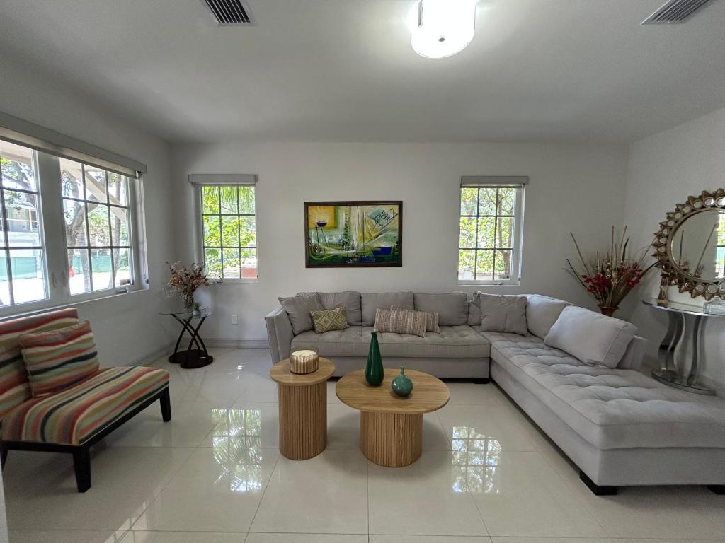una sala de estar con un sofá y una mesa en Luxury Beach Townhouse Steps from the Beach, en Pompano Beach