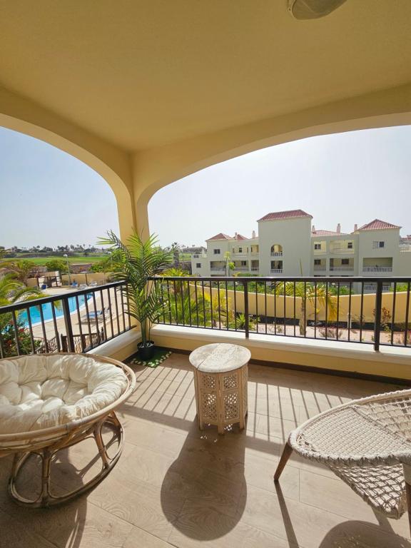 a balcony with a couch and chairs and a view at the green holes in San Miguel de Abona