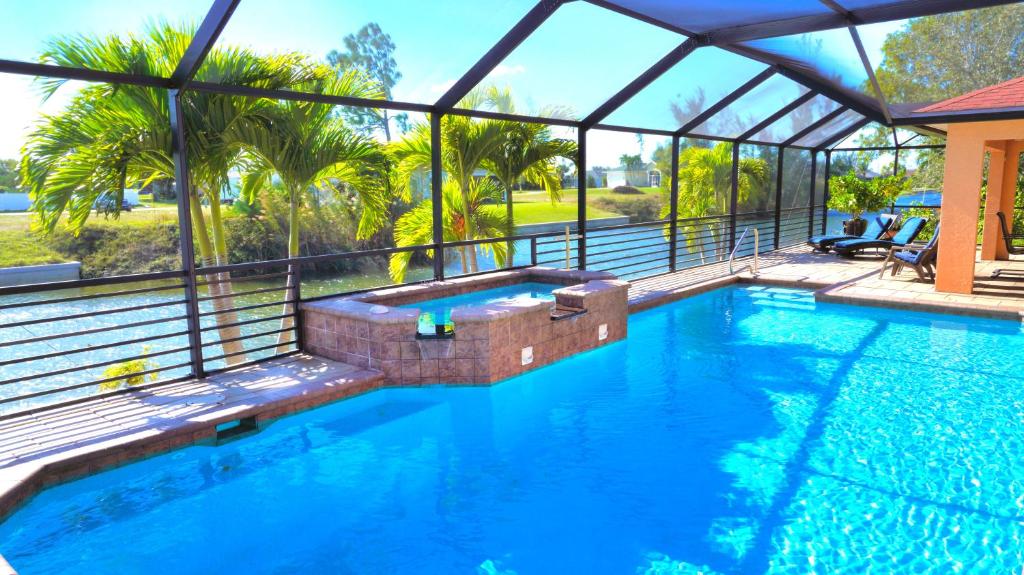 una piscina in una casa con una cabina in vetro di "Blue Diamond" heated pool house by the water a Cape Coral