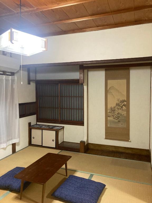 田边市お宿とごはん百々的一间房间,墙上挂着一张桌子和一幅画