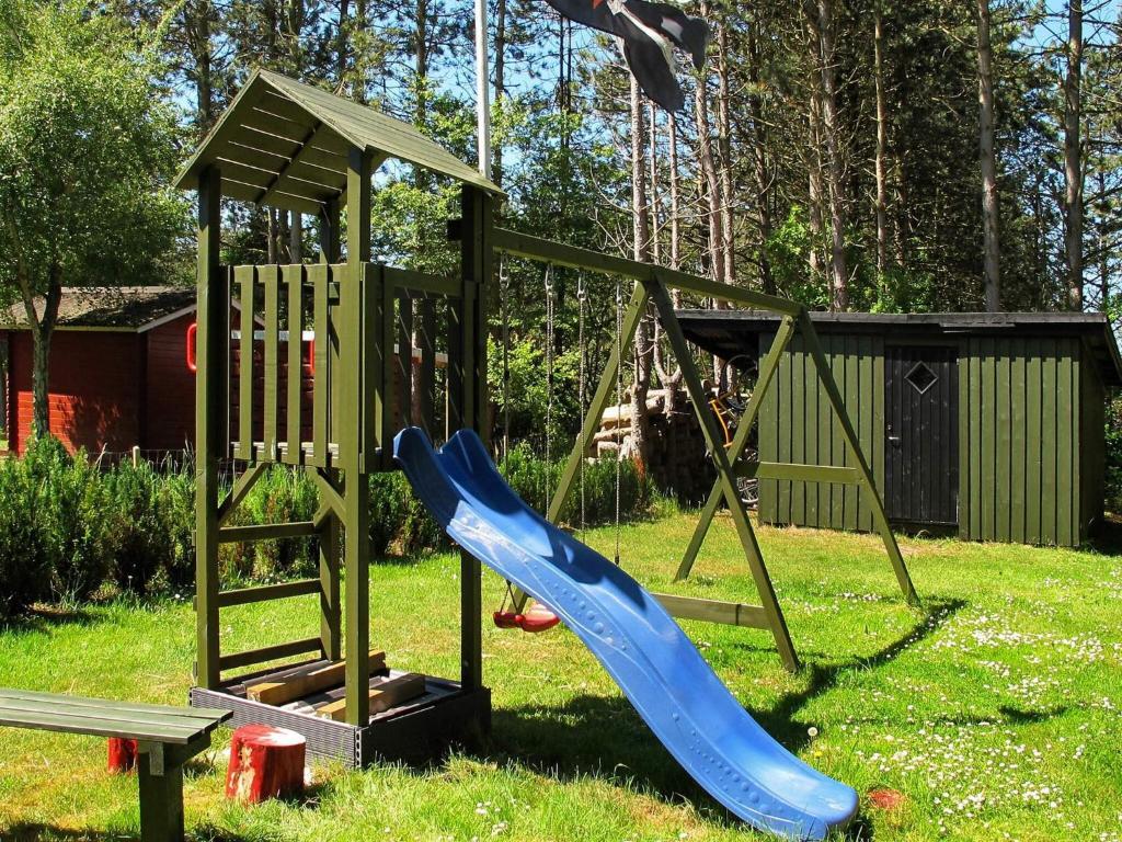 a playground with a blue slide and a swing at 8 person holiday home in Rødby-By Traum in Rødby