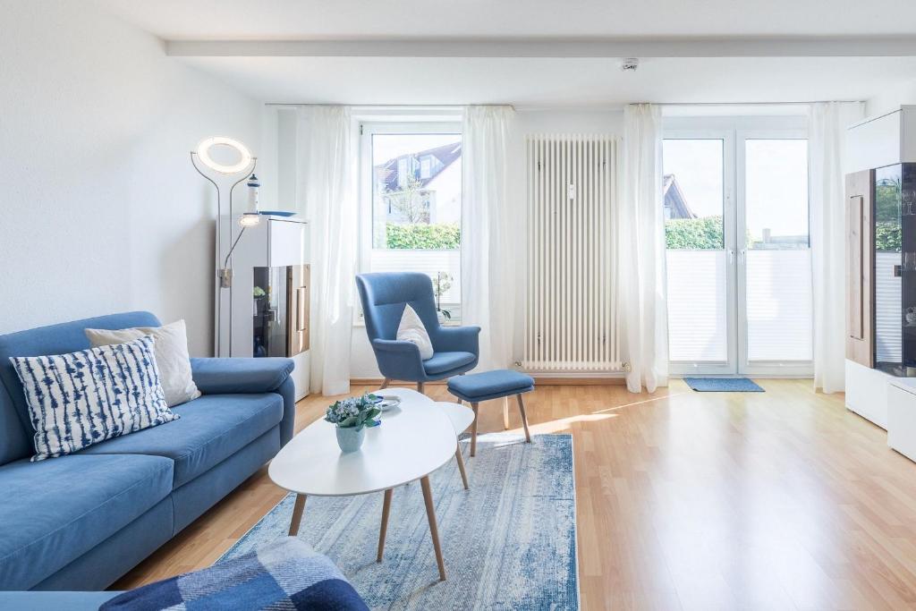 a living room with a blue couch and a table at Sünnslag Wohnung 113 in Boltenhagen