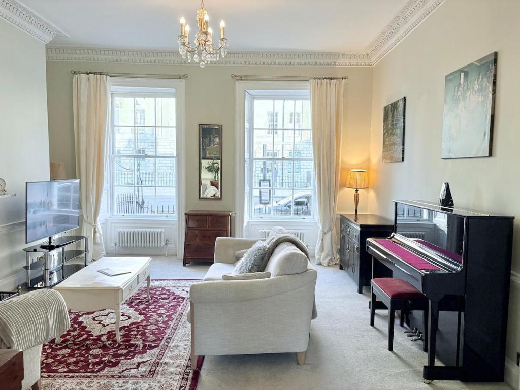 a living room with a piano and a couch at Large Quiet City Centre Holiday Home in Great Pulteney St, Bath in Bath