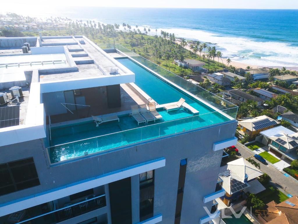 a building with a swimming pool next to the ocean at Residencial Premium Stella Maris by VLV Stays in Salvador
