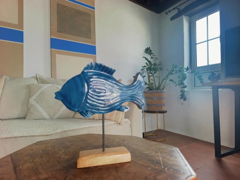 a blue glass fish statue on a table in a living room at Casa MaLuMi in Haría
