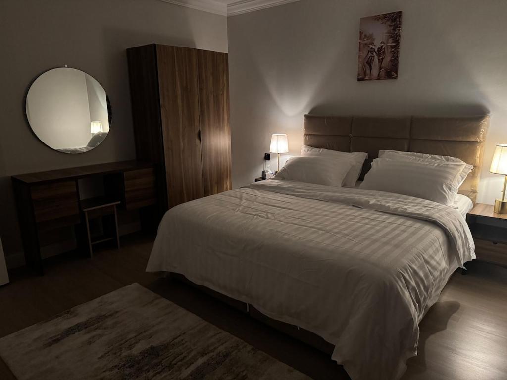 a bedroom with a large bed and a mirror at شقه بتصميم فاخر وراقي-حي السلامة in Jeddah