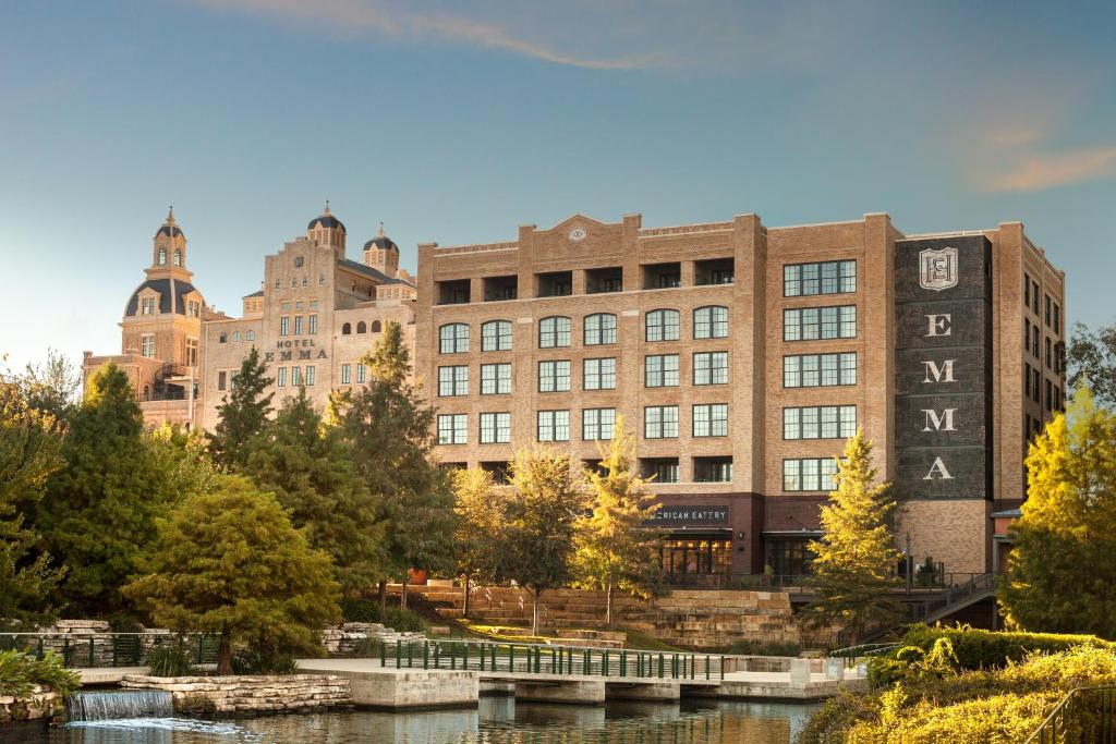 un gran edificio con un río delante de él en Hotel Emma at Pearl on the Riverwalk, en San Antonio