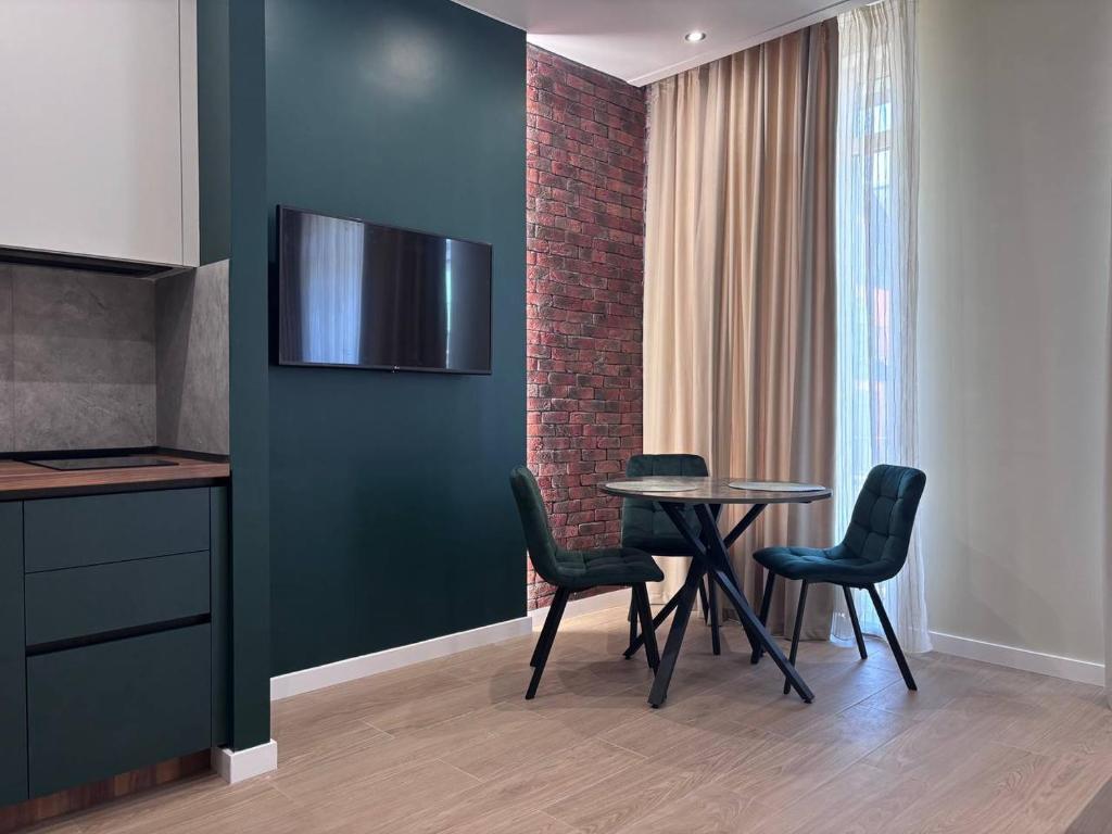 a dining room with a table and chairs and a wall at Апартаменти біля моря in Odesa