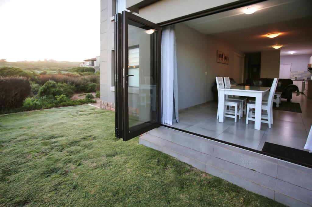 a glass extension of a house with a yard at Bella Casa, Langebaan, 4-sleeper in Langebaan