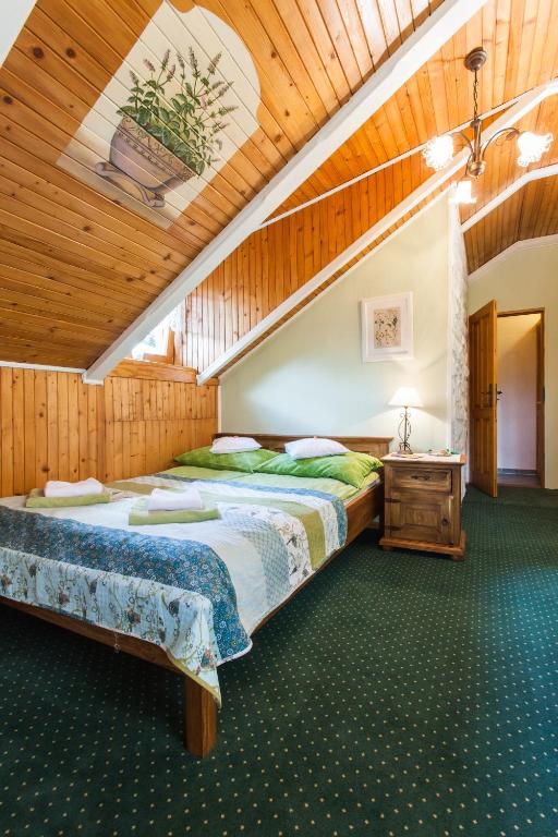 sypialnia z dwoma łóżkami i drewnianym sufitem w obiekcie Villa Cynamon w Wiśle