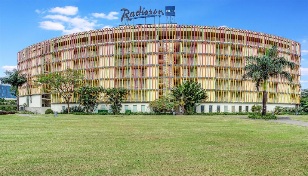 キガリにあるRadisson Blu Hotel &amp; Convention Centre Kigaliのヤシの木が前に生えている大きな建物