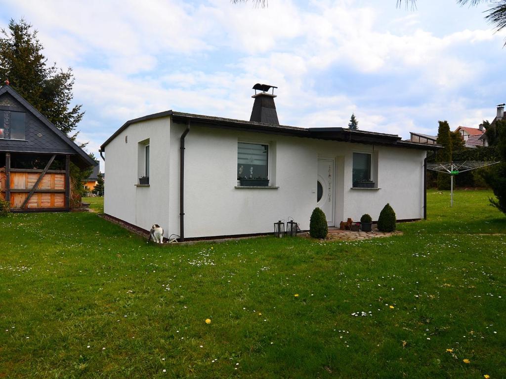 a white house with a chimney on top of a yard at Ferienhaus in Schwarzhausen in Schwarzhausen