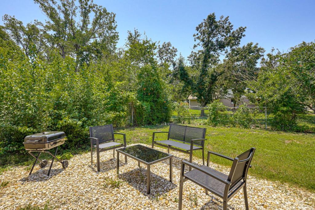 three chairs and a table and a grill in a yard at Group-Friendly Getaway with Fenced Yard in Temple! in Temple