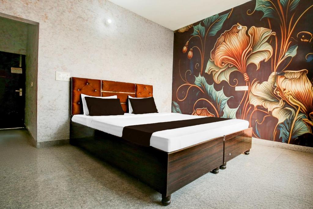 Un dormitorio con una cama grande con un cuadro en la pared. en Hotel O EB Hotel, en Amritsar