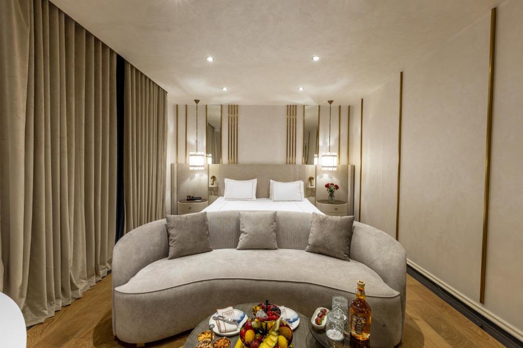 a living room with a couch and a bed at Grand Opera Hotel & Casino & Spa in Kérynia