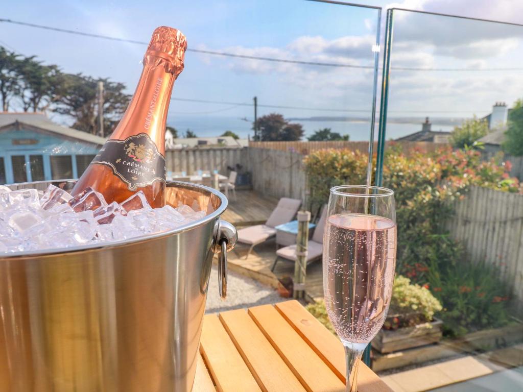 a bottle of champagne in a bucket next to a glass at Sea Breeze in Carbis Bay