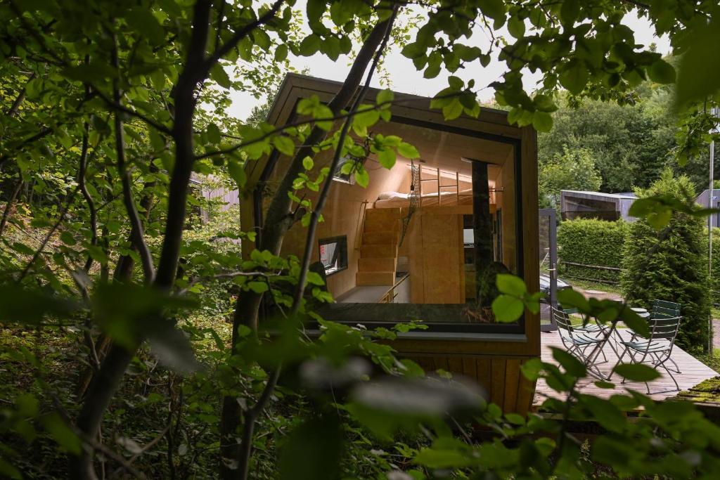 a tiny house in a garden with a mirror at Tiny House Pioneer 6 - Green Tiny Village Harz in Osterode
