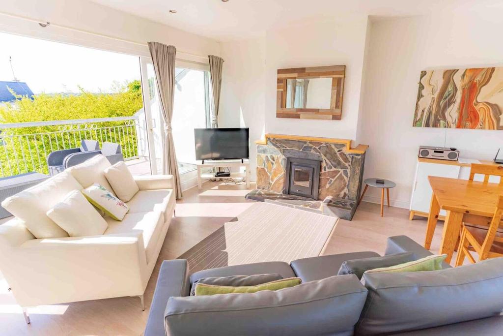 ein Wohnzimmer mit einer weißen Couch und einem Kamin in der Unterkunft 2 Bed Cottage Abersoch - close to beach and village - Pet Free in Abersoch