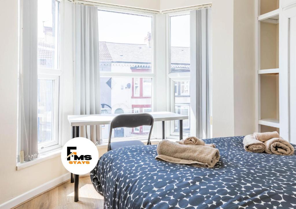 リバプールにあるFree Parking, 4 Bed, 2 Bath House, Long Term Stay Savings, Contractors, Near Anfieldのタオルが敷かれたベッドのある寝室