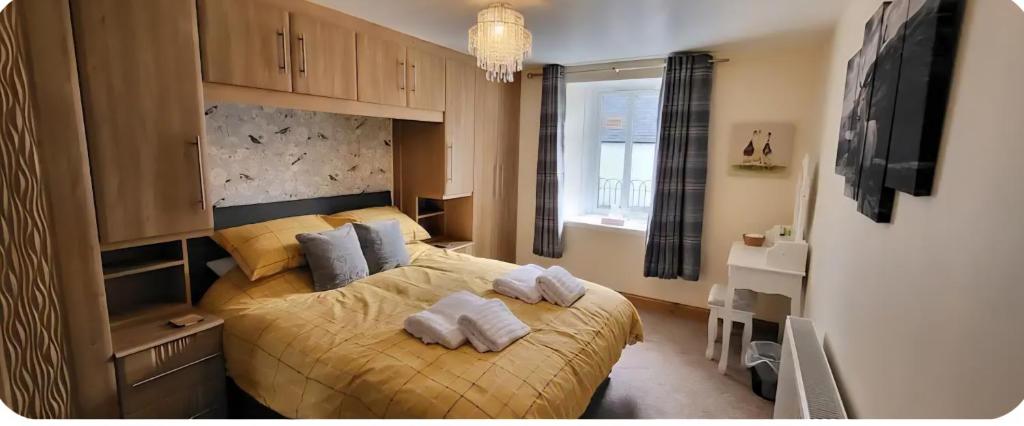 a bedroom with a bed with towels on it at Ghillies Cottage, Loch Ness in Milton