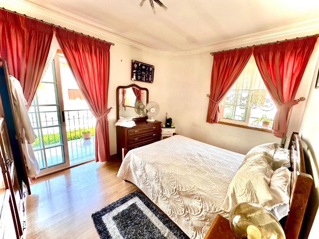a bedroom with a bed and a mirror and windows at Quarto privado Bragança in Bragança