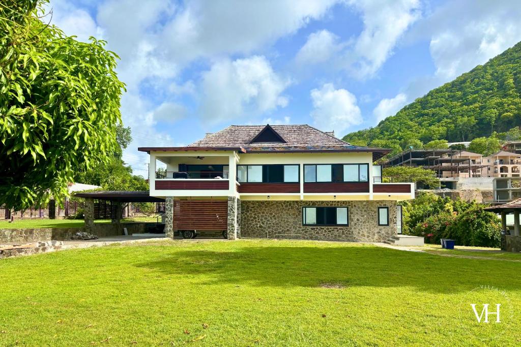 Una casa con un patio con césped en frente. en The Bougainvillea Studio at Villa Horizon, en Rodney Bay Village
