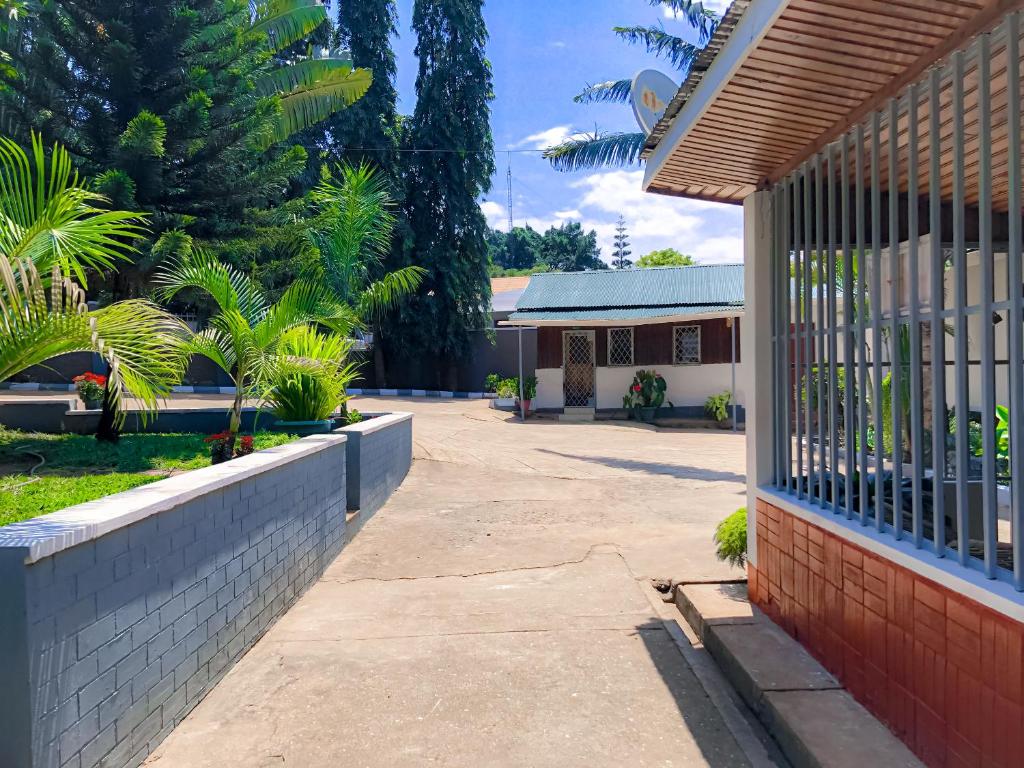 a house with a fence in front of a courtyard at Moshi Green Lodge in Moshi