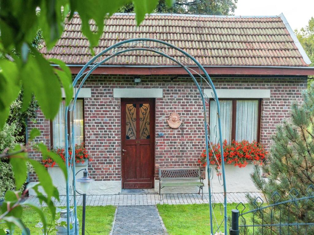 a brick house with a wooden door and a gate at Peaceful Garden Stay, Malmedy in Malmedy