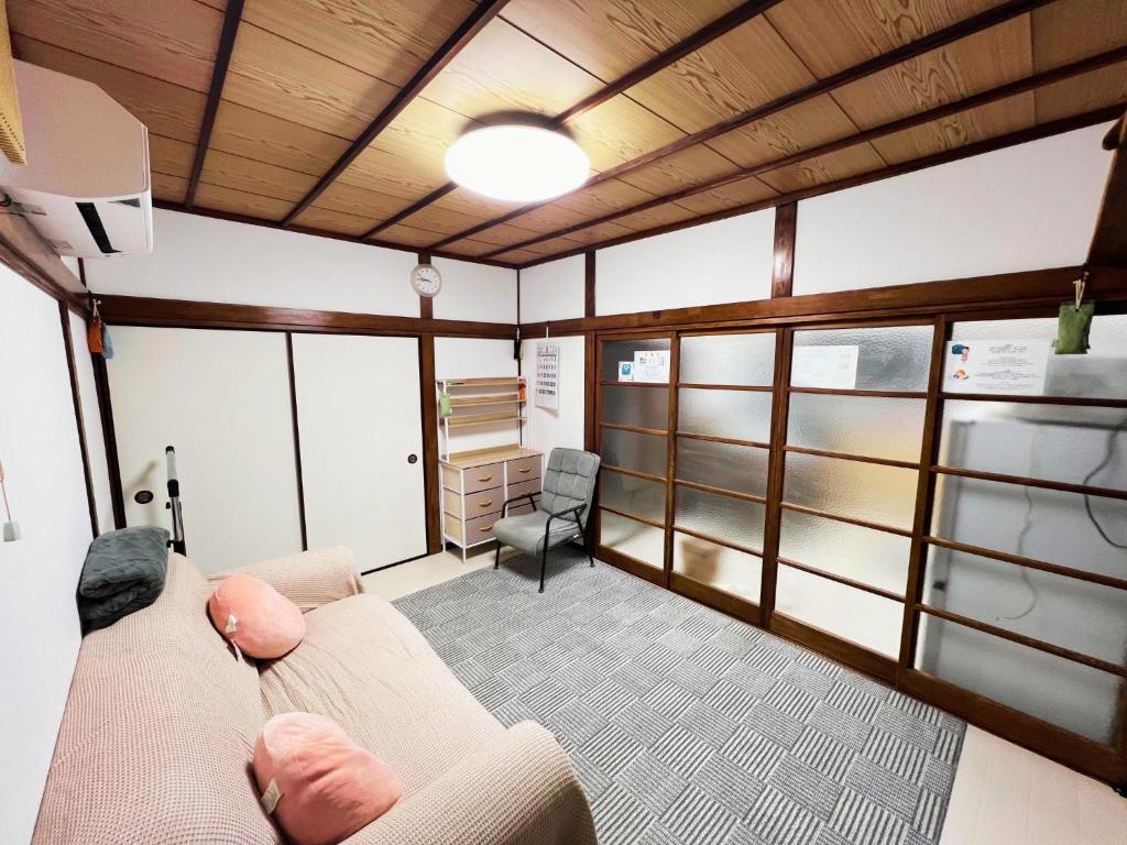 a living room with a couch and a chair at Tokyo Nukumori Lodge in Tokyo