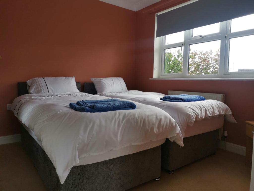 two twin beds in a room with a window at Deja Blue in Sutton on Sea