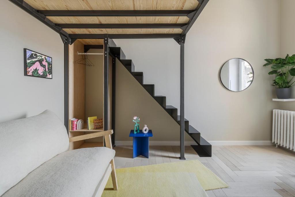 a living room with a staircase and a bed at Adorján Apartments - Sunset Studio in Oradea