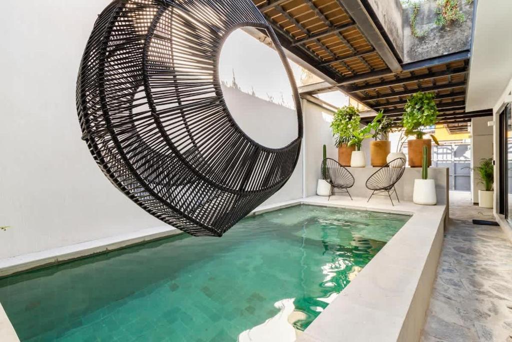 an indoor swimming pool with a wicker swing over the water at Rooftop & Private Pool Property Family in Guadalajara