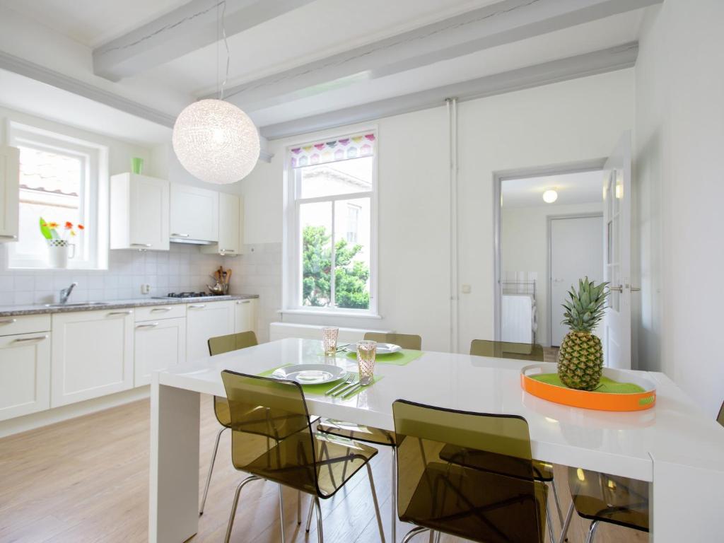 Una cocina blanca con una mesa y sillas blancas. en Holiday Home Harlingen near the Sea, en Harlingen