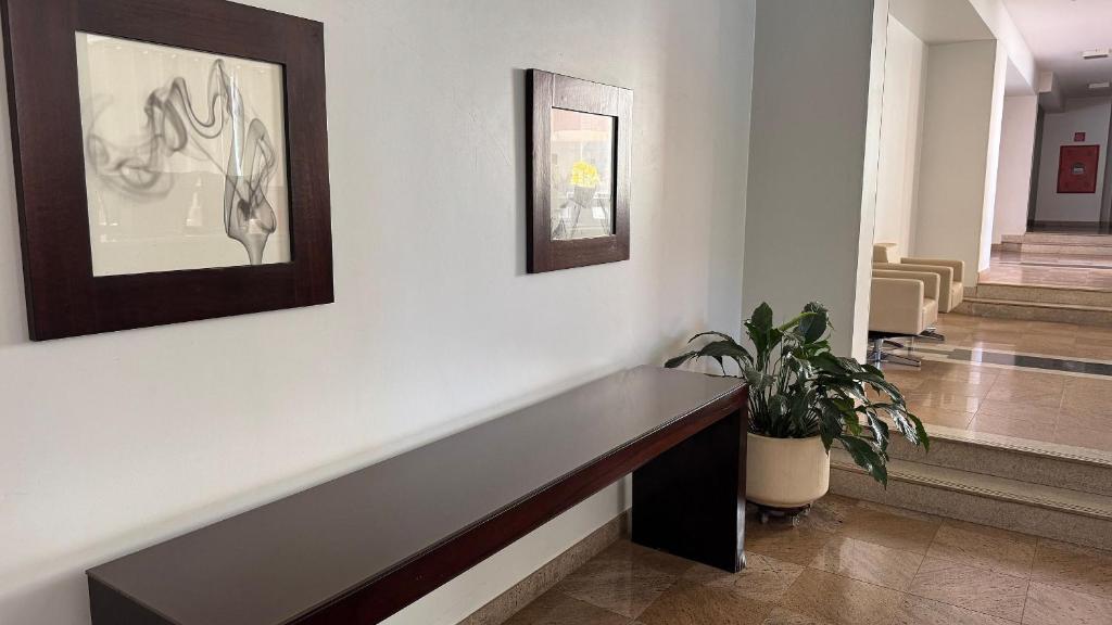 a hallway with a bench and a potted plant at Splendor Thermas in Caldas Novas