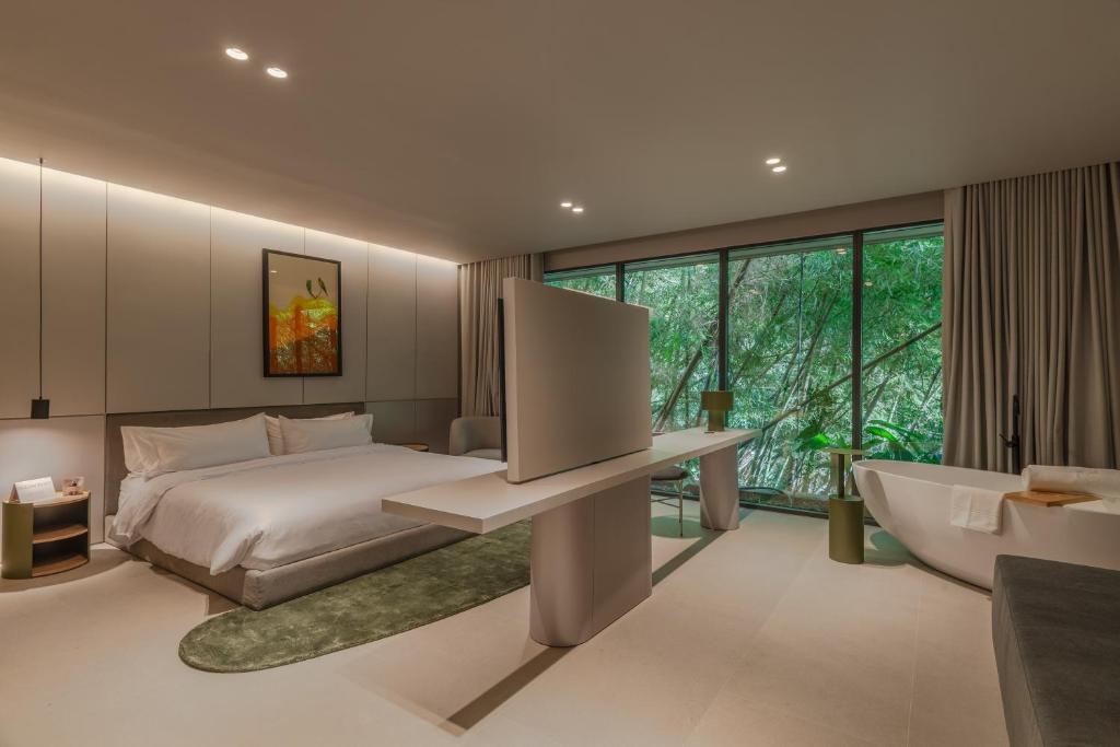a bedroom with a bed and a large window at Wake BioHotel in Medellín