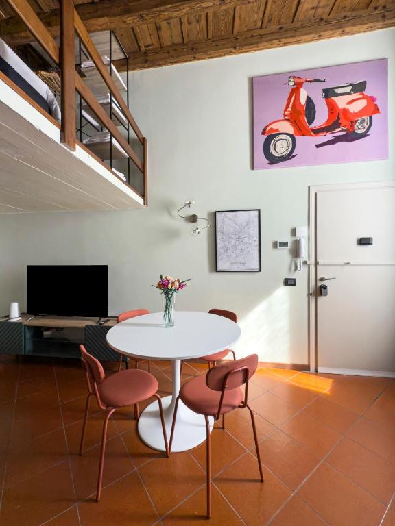 a dining room with a table and chairs and a scooter at Arrivederci Apartment in Bergamo