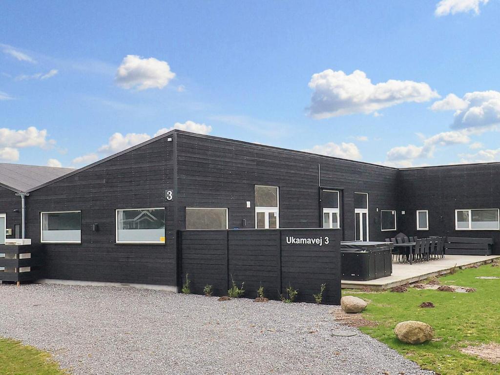 a black building with a sign on the side of it at 5 star holiday home in Væggerløse in Bøtø By