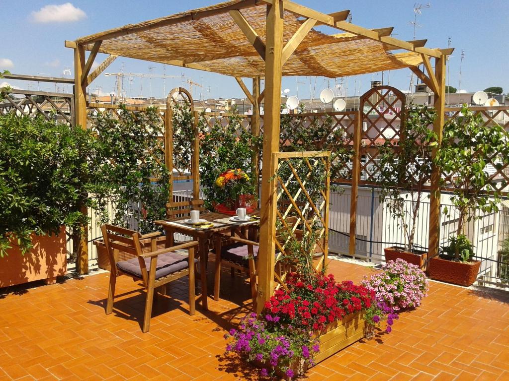 a patio with a table and chairs and flowers at Holiday rental St Peter's area in Rome