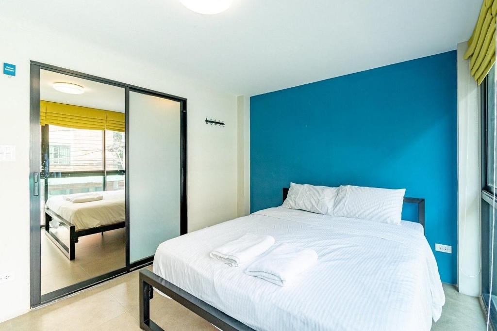 a bedroom with a large bed with a blue wall at Lachata Bangkok in Bangkok