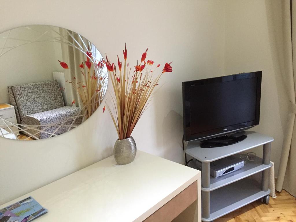 a living room with a tv and a vase on a table at Apartments Jani in Hvar